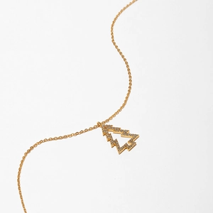 Detail of a gold-colored necklace with a hollow Christmas tree pendant pavé-set with zircons