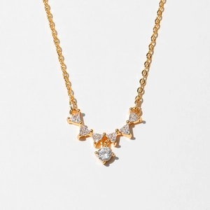 Macro view of gold starfish necklace pendant with white zircon crystals on white background
