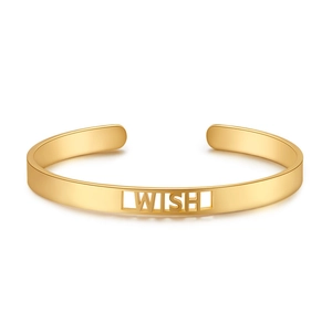 Detail der goldenen WISH-Gravur an einem minimalistischen offenen Armreif aus Metall