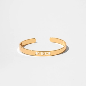 Elegante bracciale rigido aperto dorato con scritte LUCKY e WISH in metallo minimalista