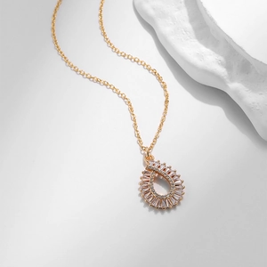 Dettaglio del ciondolo a cuore dorato con micro zirconi su una sottile collana