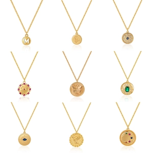 Collection of nine gold necklaces with diverse pendants like coins and colorful gemstones