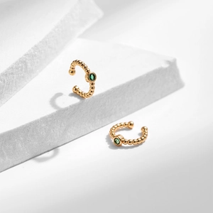 Détail de boucles d'oreilles clips perlées en or avec pierres de zircon vert