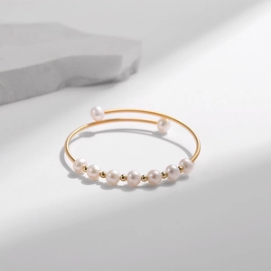 Makroaufnahme von Süßwasserperlen-Goldarmreif mit Spiral-Draht und elastischem Design