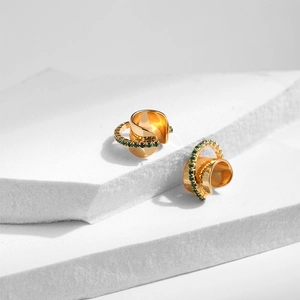 Détail de la bague d'oreille dorée multicouche avec pierres de zircone vert émeraude
