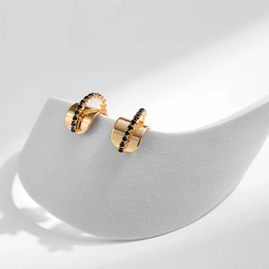 Détail de boucles d'oreilles papillon multicouches plaquées or avec zircons noirs élégants