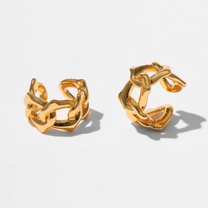 Détail de boucles d'oreilles dorées avec texture fluide en métal liquide et chaînes