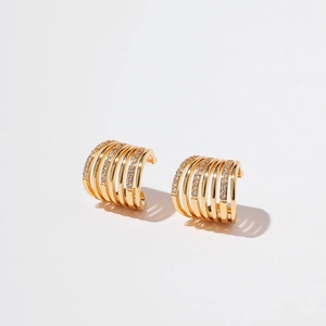 Detailed view of layered gold ear cuff featuring sparkling cubic zirconia and polished bands