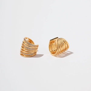 Detail of gold multi-layer ear cuffs with cubic zirconia and polished metal finish