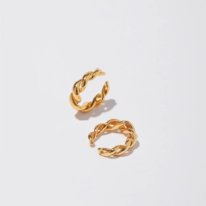 Detailed macro shot of 18K gold plated twisted rope texture on modern ear cuff earrings