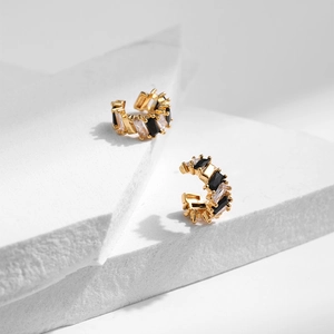 Detail of 18K gold plated C-shaped ear cuffs with black and white zircon stone inlay