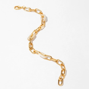 Gros plan détaillé du bracelet en chaîne plaqué or 18K avec maillons en résine blanche et fermoir