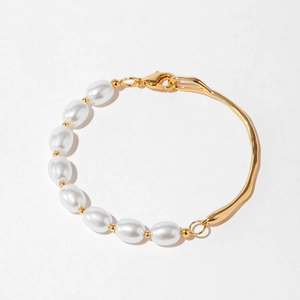 Détail du bracelet asymétrique avec perles blanches et barres en métal doré 18 carats