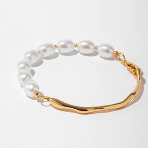 Détail du bracelet en perles avec barre plaquée or 18K ondulée et fermoir mousqueton