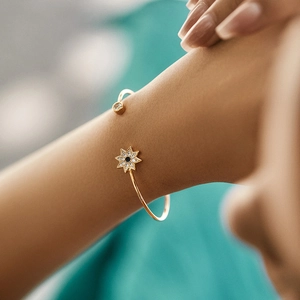 Gold open bangle with blue gemstone star and clear crystal accents for women