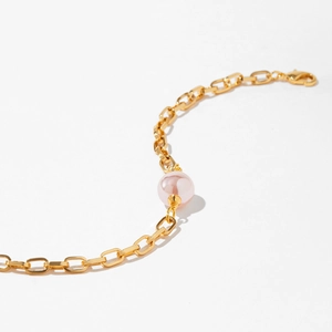 Détail du bracelet chaîne en or 18K avec une perle rose et un fermoir mousqueton
