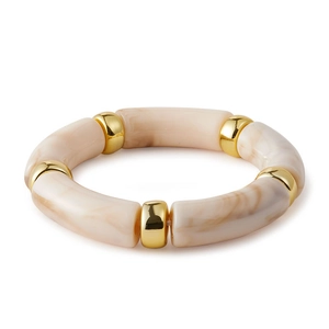 Macro shot of chunky cream acrylic bangle with marbled textures and golden metal accents