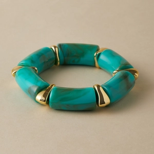 Close-up of turquoise resin beads with marble pattern and polished gold metal spacers