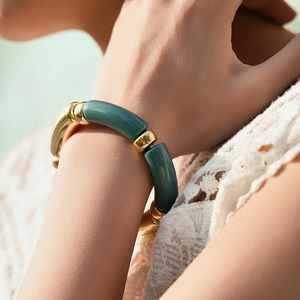 Detail of stretch bracelet with polished gold metal and matte teal resin segments