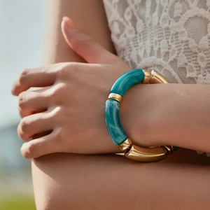 Detailed shot of handmade elastic bracelet with blue marble resin and gold metal tubes