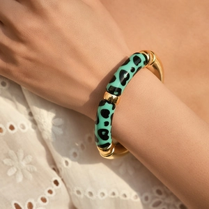 Close-up of mint leopard print and gold metal links stretch bracelet on a female wrist
