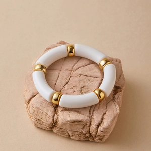 Detail view of Bohemian acrylic stretch bracelet on a pink textured stone backdrop