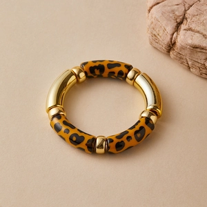 Close-up of bohemian elastic bracelet featuring leopard print resin and gold metal tubes