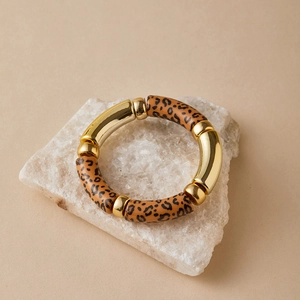 Detail of bohemian gold metal and leopard print resin tubes on the stretch bracelet