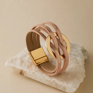 Vue détaillée du bracelet multicouche en cuir rose avec anneau doré et fermoir magnétique