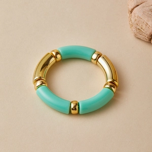 Detail of mint green acrylic tubes and polished gold metal beads on elastic bracelet