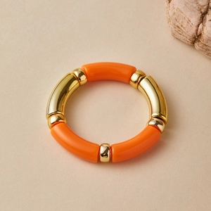Detail of orange resin beads and gold metallic spacers on a bohemian stretch bracelet