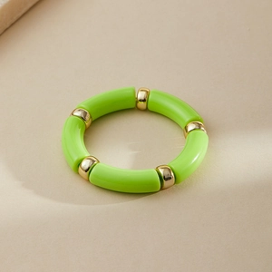 Detail of green acrylic tube beads and gold metal spacers on an elastic ring