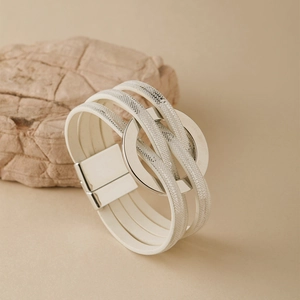 Détail d'un bracelet bohème multicouche en cuir blanc avec paillettes et fermoir magnétique