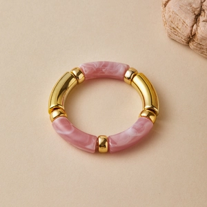 Detail of pink marble resin bamboo tubes and gold metal spacers on elastic bracelet