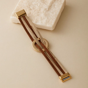 Détail d'un bracelet bohème multicouche marron et beige avec un fermoir magnétique doré