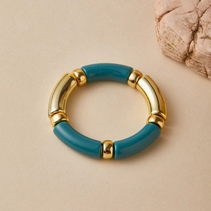 Detailed top view of a bamboo-style stretch bracelet with dark green resin and gold beads