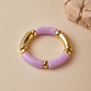 Macro detail of elastic bracelet with purple marble resin and gold metal curved tubes