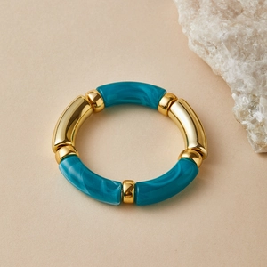 Detail of handmade elastic bracelet with marble resin and gold metal segments