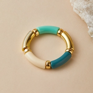 Detail of vintage beaded elastic bracelet featuring gold metal and resin curved tubes