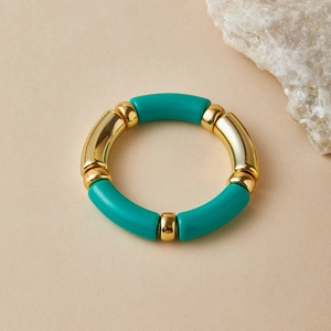 Detail of bohemian stretch bracelet featuring gold metal tubes and turquoise resin beads
