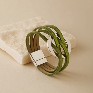 Détail d'un bracelet multicouche vert herbe en cuir avec anneau argenté et fermoir aimant
