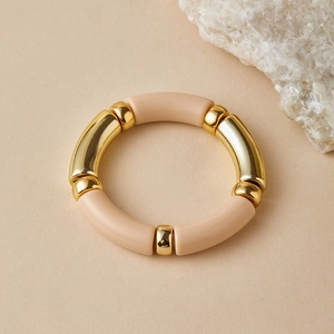 Detail of bohemian stretch bracelet with beige resin bamboo beads and polished gold accents