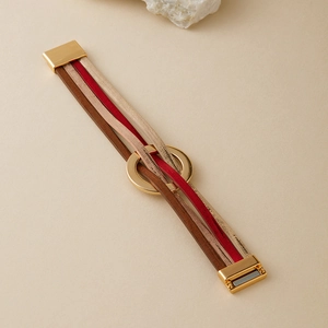 Détail d'un bracelet multicouche en cuir avec anneau en métal doré et fermoir magnétique
