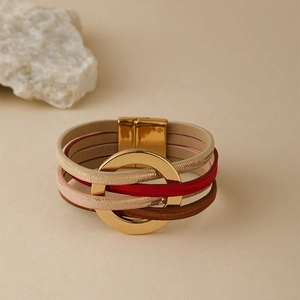 Détail d'un bracelet bohème multicouche en cuir avec grands anneaux dorés et fermoir