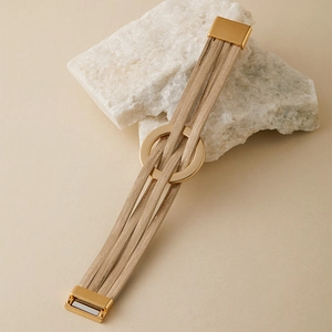 Détail du bracelet bohème multicouche or champagne avec fermoir magnétique sur pierre blanche