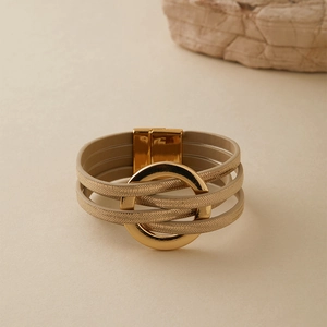 Détail d'un bracelet bohème multicouche en cuir avec anneau doré et fermoir aimanté
