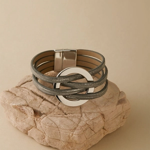 Détail d'un bracelet multicouche en cuir gris avec anneau argenté et fermoir aimanté