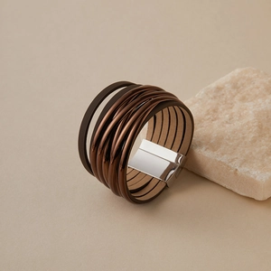 Details eines mehrlagigen Lederarmbands im Boho-Stil mit Magnetverschluss auf Stein