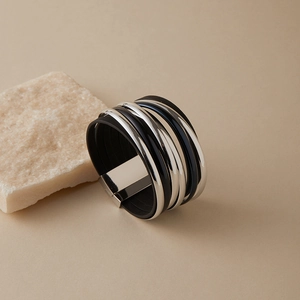 Detail eines mehrlagigen Lederarmbands im Boho-Stil mit Ringen und Silberverschluss