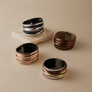 Detail von mehrlagigen Lederarmbändern mit Metalllinien und Magnetverschluss-Design